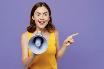 Young surprised woman 20s she wear yellow tank shirt hold scream in megaphone announces discounts...