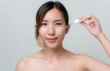 Obraz na płótnie Canvas Asian woman is stopping skin serums for her face to make skin soft, moisturized, white and clear.