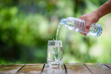 Clean drinking water poured into glasses placed on a wooden bar.