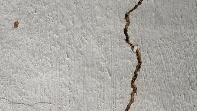 Camera movement along a crack in the ceiling. Clay ceiling of an old house with a large gap. A long break in the wall due to natural disasters. Condition of housing after explosions and earthquakes