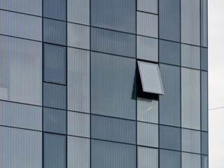 Obraz premium Close-up photo of a modern business building with one open window 