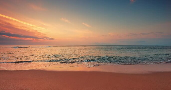 Color sunrise over ocean beach. Splashing sea waves on the coast sand, 4K video of seascape view