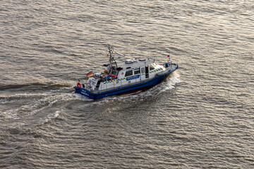 Moving control ship of German Water Police on Elbe river in Hamburg from bird's eye view. 