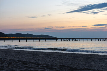 Silhouette of a bridge in the sea at sunset.