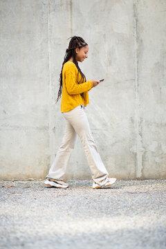 Stylish Young African Woman Texting On Mobile Phone Outdoors In City