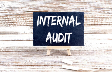 INTERNAL AUDIT text on the Miniature chalkboard on wooden background
