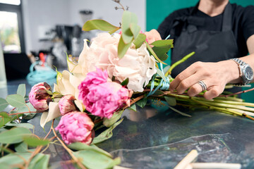 Close-up of female florist hand holding delicate bouquet of flowers