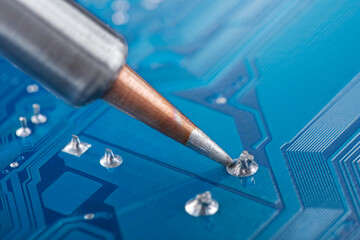 soldering electronic components onto the PCB. Electronics repair and digital technology.