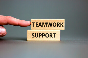 Teamwork support symbol. Concept words Teamwork support on wooden blocks on a beautiful grey table grey background. Businessman hand. Business and teamwork support concept. Copy space.