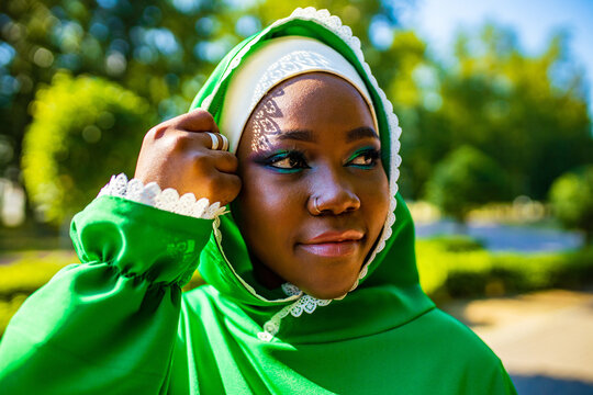 modern authentic multicultural race islamic woman in green cotton hijab with gorgeous make up outdoors in summer park