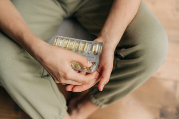 Close-up woman holding pack of omega 3 fish oil capsules