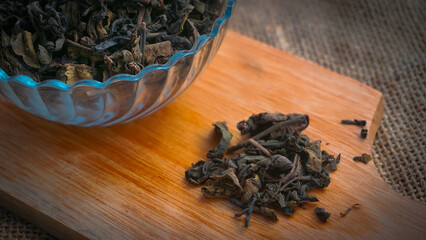 Dried roasted green tea leaves on the bowl on burlap background, Japanese tea, Houji tea