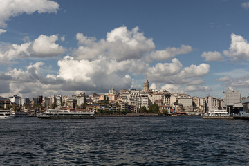 Fototapeta na wymiar View of tour boats on Golden Horn area of Bosphorus in Istanbul. Galata tower and Beyoglu district are in the background. It is a sunny summer day.