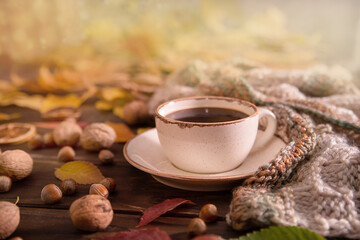 Autumn, autumn leaves, a hot cup of coffee and a warm scarf on a wooden table background. Seasonal, morning coffee, sunday rest and still life concept.

