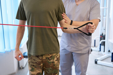 Physiotherapist helping a patient in gym of the rehabilitation center