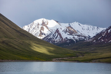 Lake Kol Akok and high mountain peaks in the Tian Shan mountain range of Kyrgyzstan.