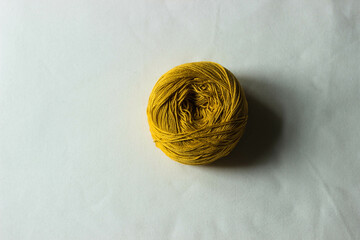 a ball of yellow yarn made of cotton, polyester for knitting sweaters, jackets, tops