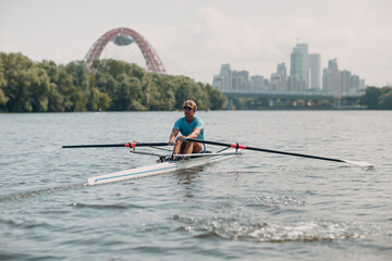 Sportsman single scull man rower rowing on boat at Moscow River Russia