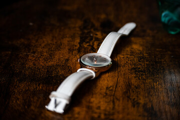 A watch laying on a dark wooden table