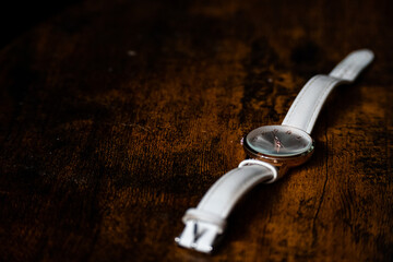 A watch laying on a dark wooden table