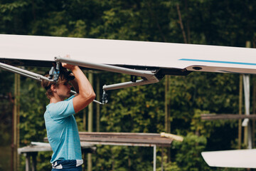 Sportsman single scull man rower prepare to competition with boat. © primipil
