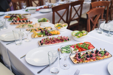 Catering table, beautifully decorated banquet with variety selection of different food snacks and appetizers on a corporate birthday party event or wedding celebration, delicatessen setting
