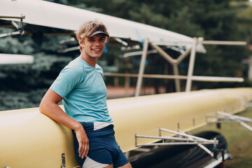 Sportsman single scull man rower portrait sitting relaxing after training competition against...