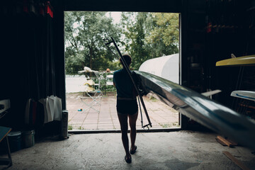 Sportsman single scull man rower prepare to competition with boat. © primipil