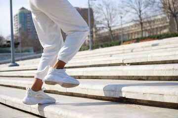 Female legs on stairs. Routine running. at the park