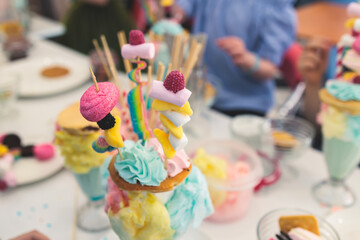 Over shake and freak shake, process of cooking extreme colorful milkshakes on a kids birthday party celebration, catering banquet table with candy sweets desserts, monster shakes