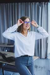 Business woman in the office with glasses in her hands. Woman manager in glasses and white shirt in the office. Working day manager