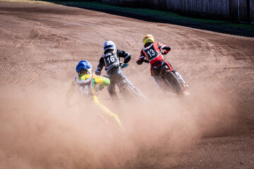 three speedway bikers on the track make a lot of dust - obrazy, fototapety, plakaty