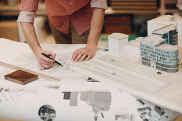 Architect with blueprints and layout design project at office bureau