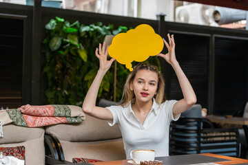 Cute blonde holding idea board top of her head and looking aside
