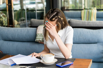 Young workaholic sittign at the restaurant and working