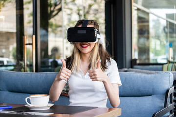 Smiling lady wearing VR set and gestures thumbs up