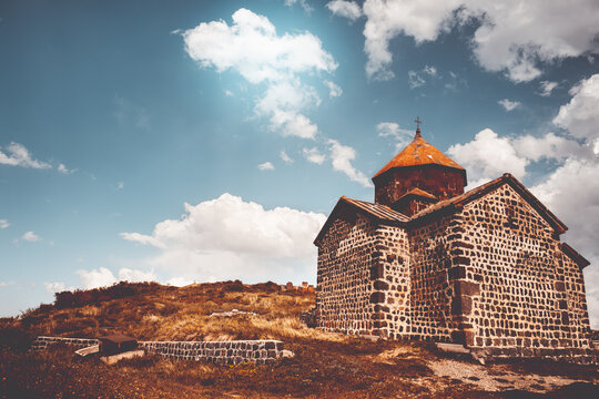 Ancient chapel in Armenia. Tourism and traveling destination. Old stone church of S. Karapet part of the Sevanavank monastery, Lake Sevan. Best famous travel location. Retro vintage orange tone filter
