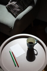 coffee cup and blank card on table in harsh sunlight