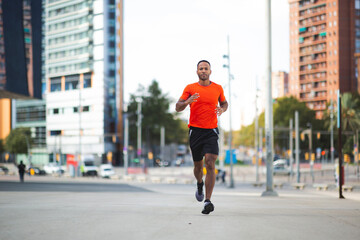 Male athlete running outdoors on city street