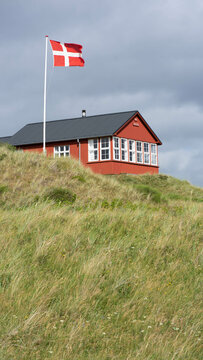 Ferienhaus in Dänemark in den Dünen, rot mit dänischer Fahne