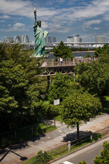 Fototapeta premium Odaiba Statue of Liberty with Tokyo skyline in the background in Odaiba Marine Park