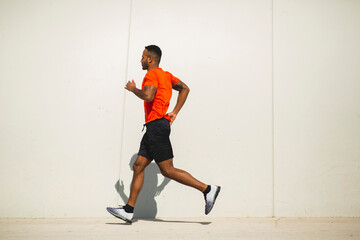 Young sportsman jogging outdoors in city