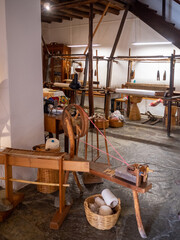A spinning wheel and a loom in a traditional wool artisans workshop in Mertola