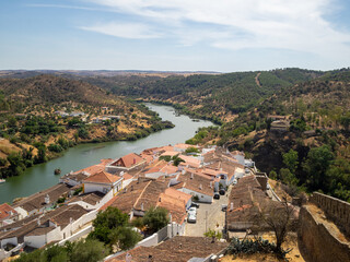 Fototapeta na wymiar General view of Mertola inner castle walls housing seen from the Castle Tower and with Guadiana River and Alentejo hills