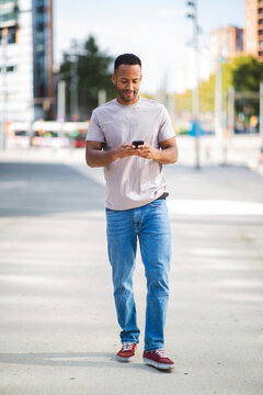 Man text messaging using mobile phone outdoors in city