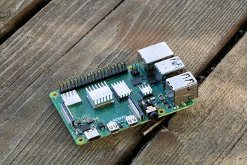 Raspberry PI 4B Microcomputer sitting on wooden table outdoors