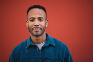 Handsome man smiling over maroon bacckground