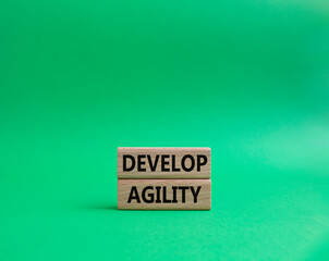 Develop agility symbol. Concept word Develop agility on wooden blocks. Beautiful green background....