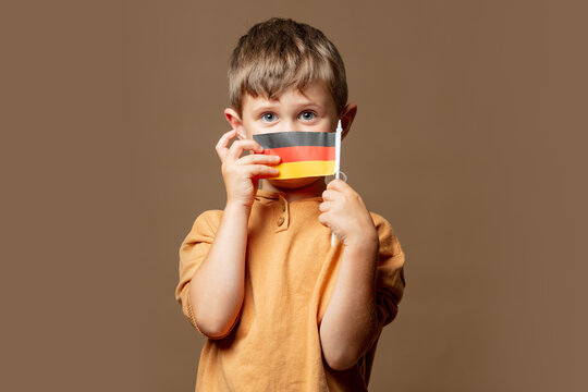 Little Kid Boy With German Flag On Brown Background