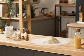 Horizontal image of homemade dough with flour on wooden kitchen table preparing for baking